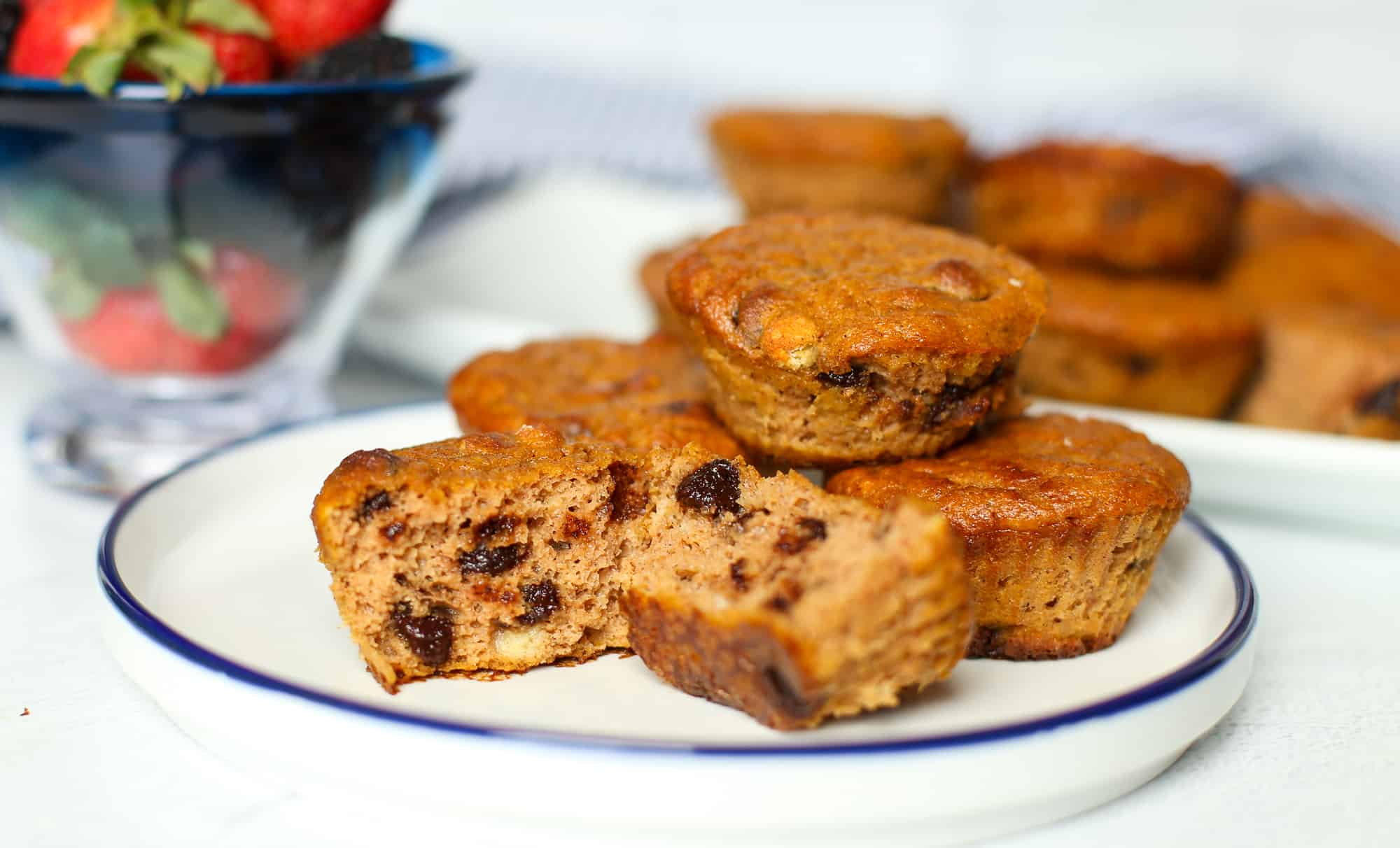 Gluten-free pumpkin chocolate chip muffins stacked on a plate.