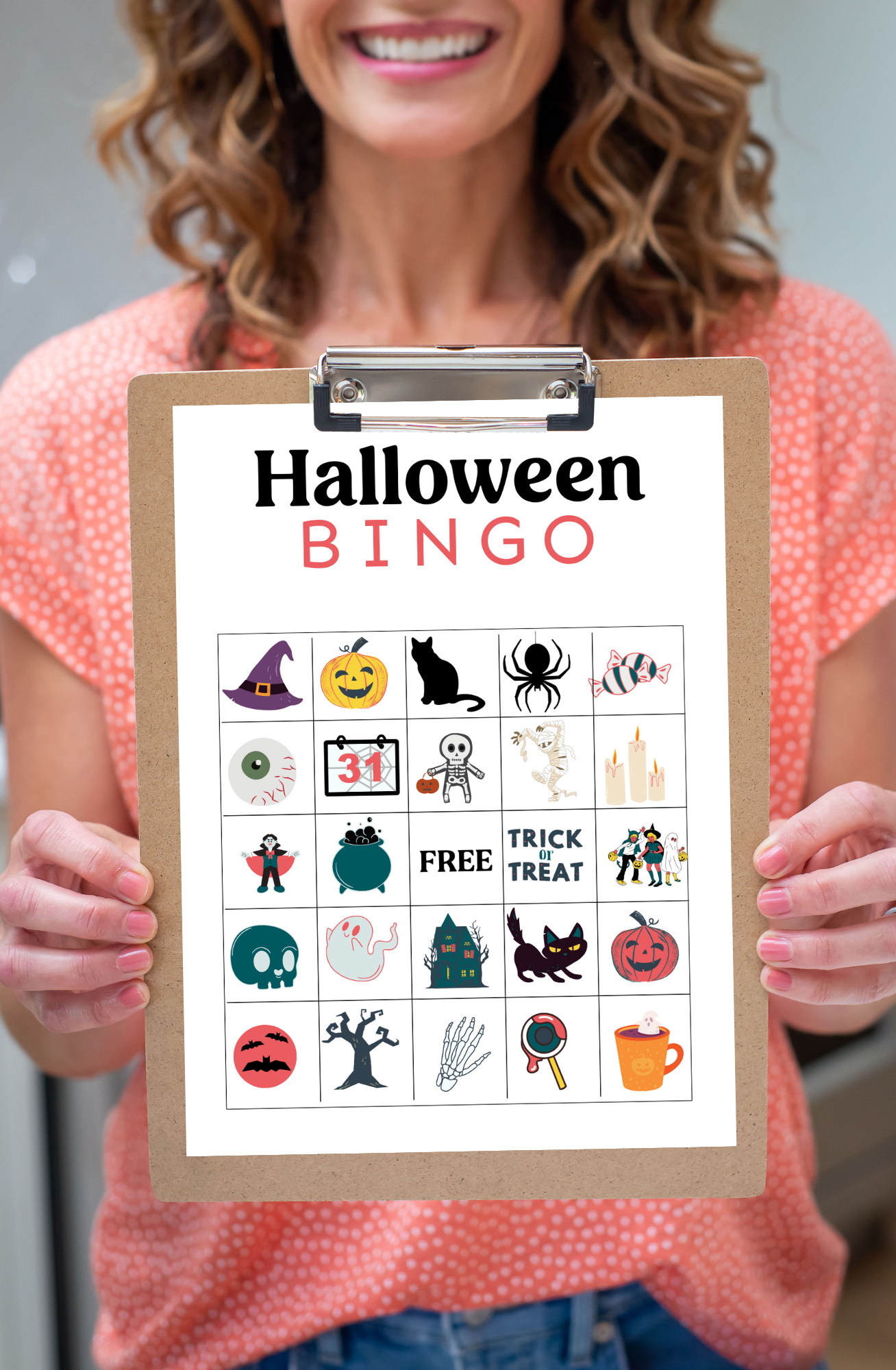 Woman holding halloween bingo card on a clipboard