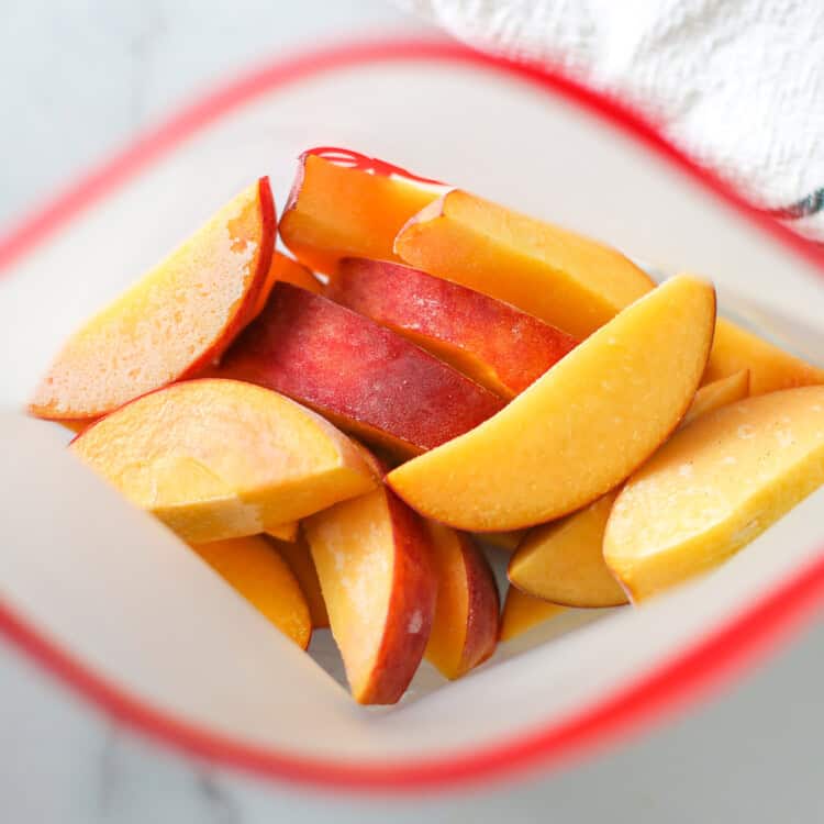 Frozen peach slices in a reusable freezer bag.