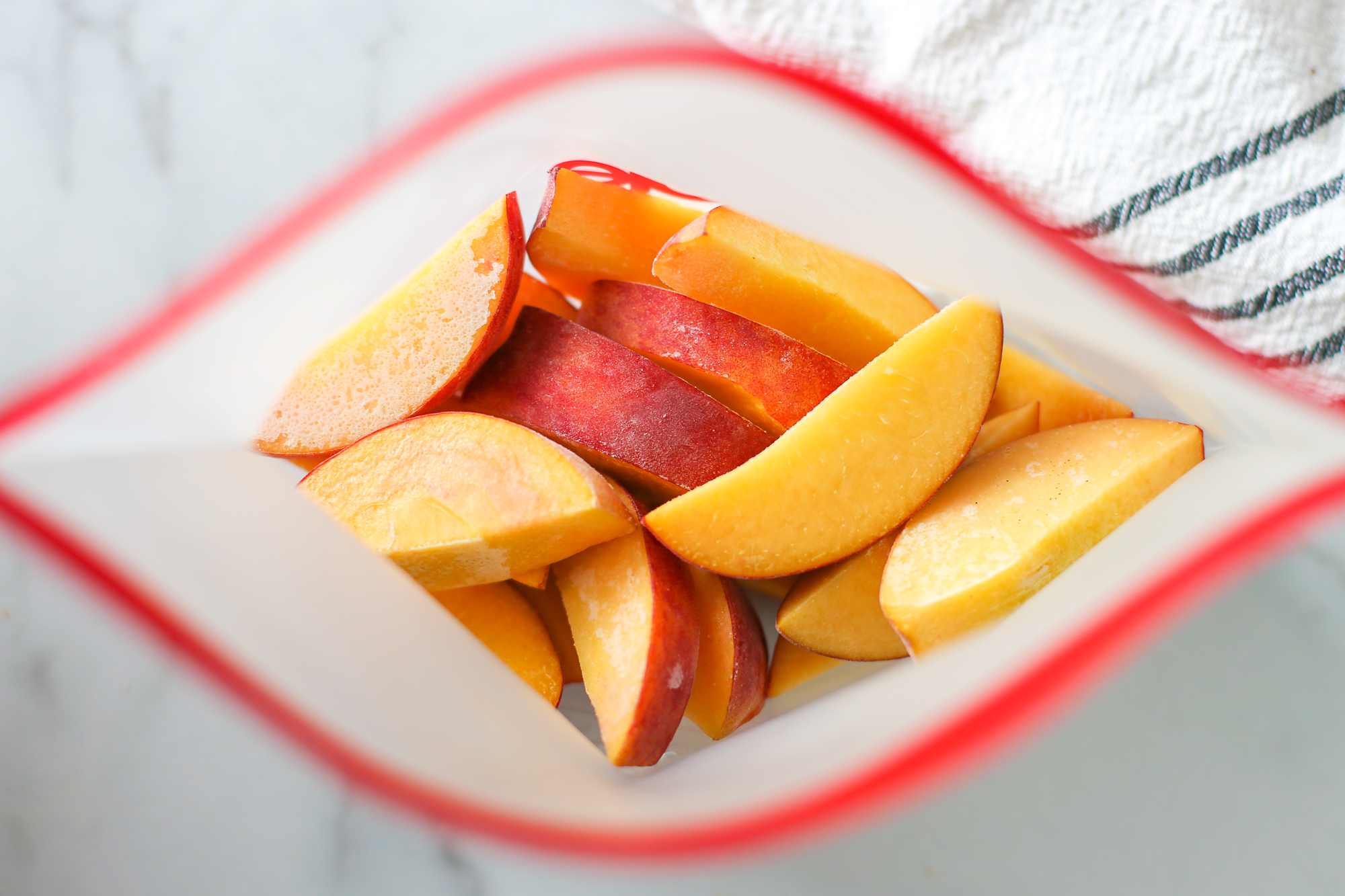 Frozen sliced peaches in a reusable freezer bag.