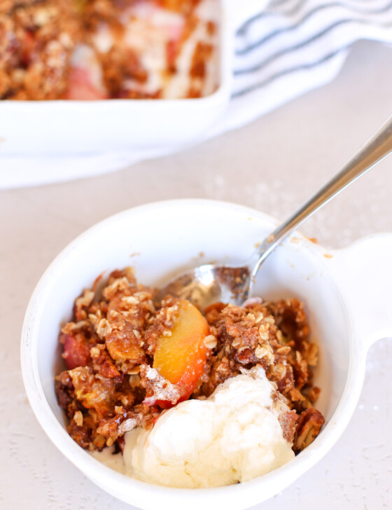 peach crisp in bowl with spoon
