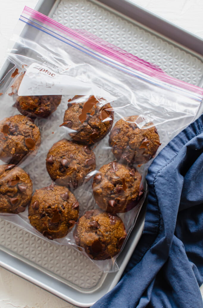 Pumpkin chocolate chip muffins in a freezer bag on a baking sheet ready to go to the freezer.