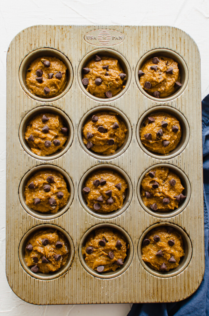 Muffin tin filled with pumpkin chocolate chip batter