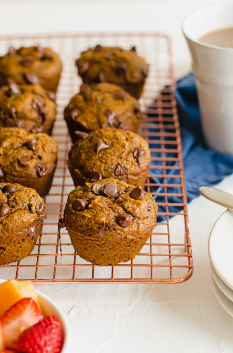 Pumpkin chocolate chip muffins lined up on a cooling rack.