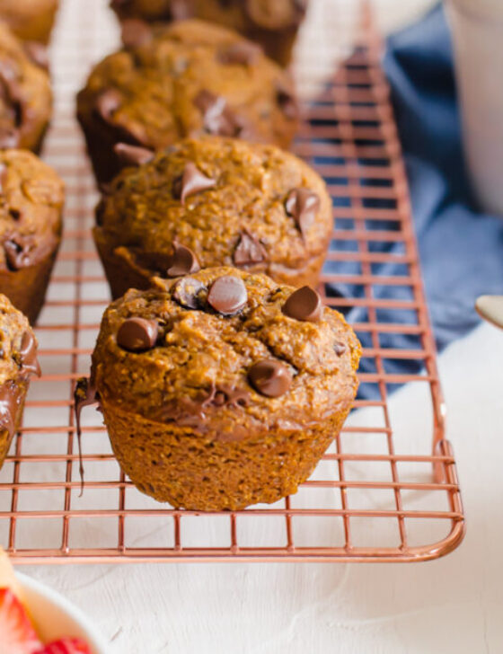 Pumpkin chocolate muffins on a cooling rack.