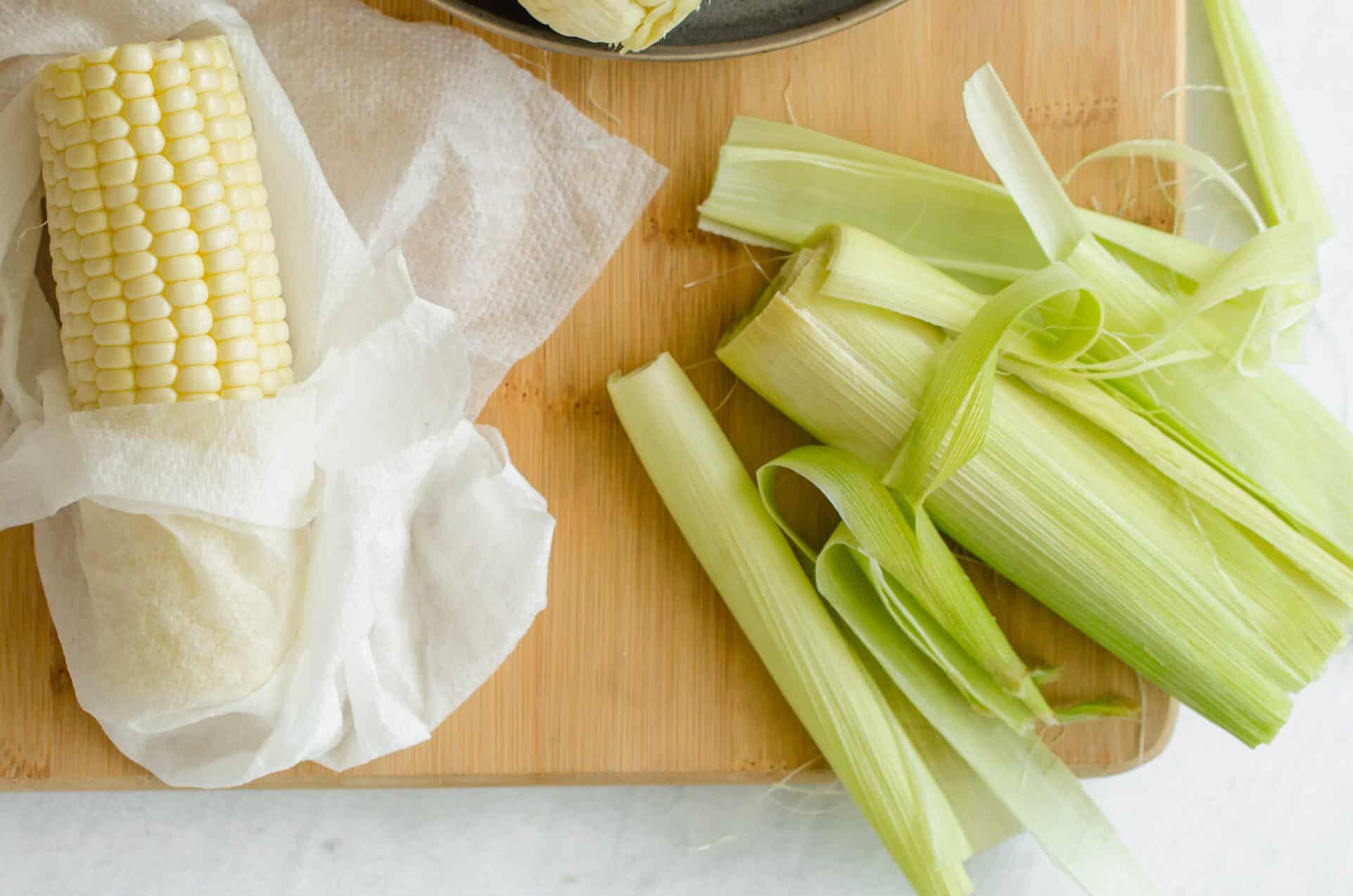 Raw corn without husk wrapped in a damp paper towel