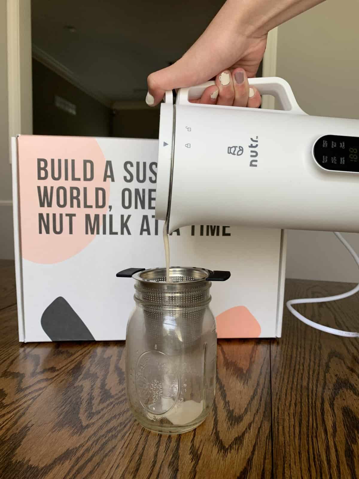 Pouring almond milk through a strainer.