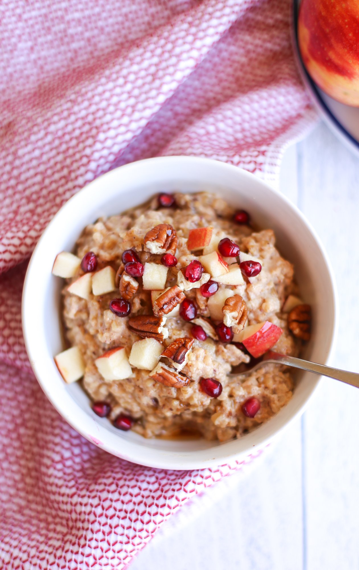 Apple cinnamon steel cut oats with pecans and pomegranate seeds on top. 