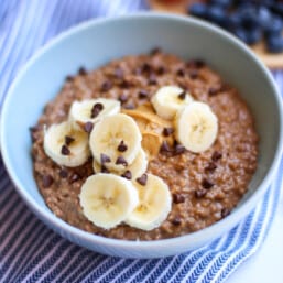 Instant Pot steel cut oatmeal topped with banana, peanut butter and chocolate chips.