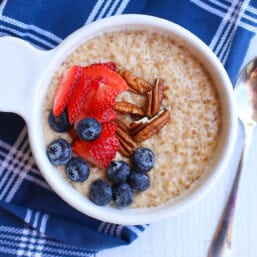 Instant pot steel cut oats with sliced strawberries, blueberries, and chopped pecans on top.