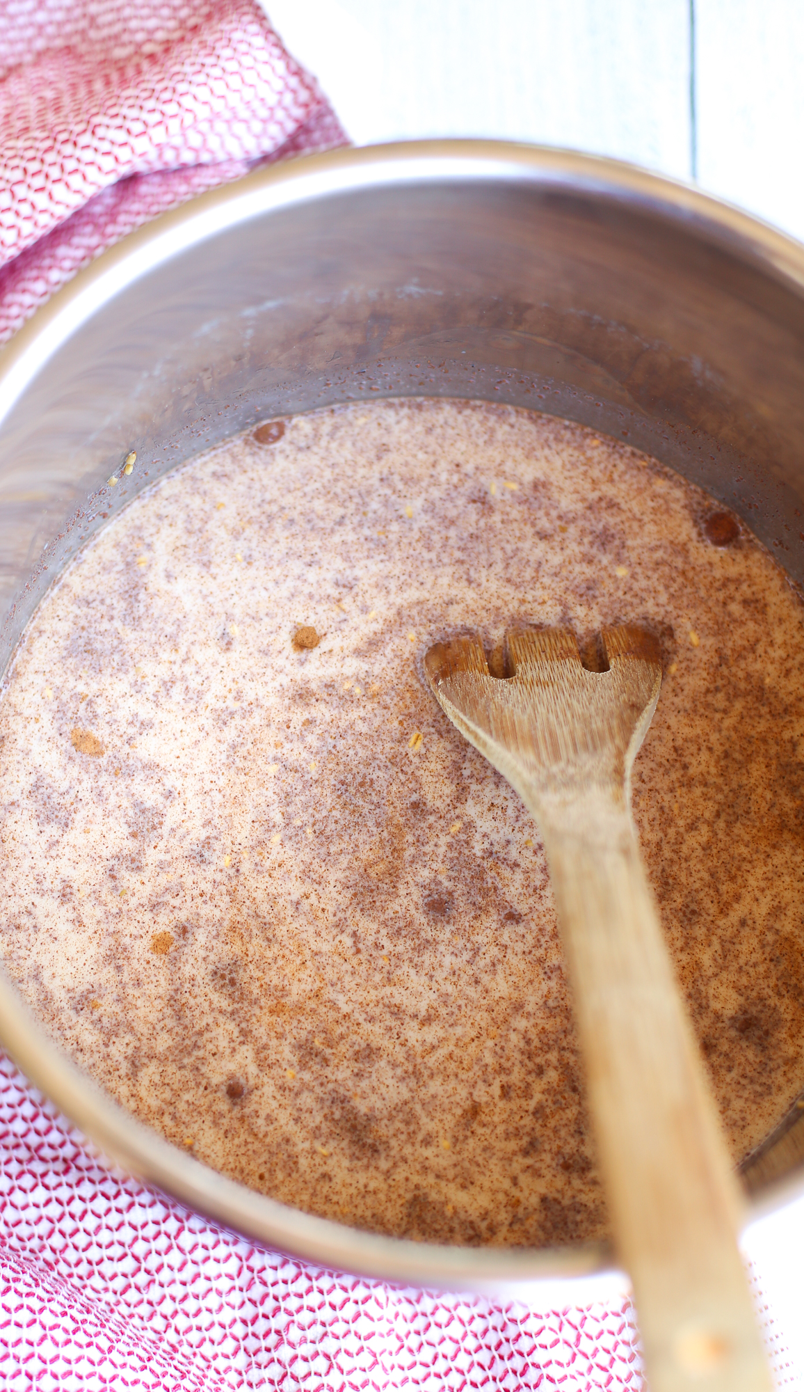 Stirring milk and other ingredients in an Instant Pot for brown sugar steel cut oats.