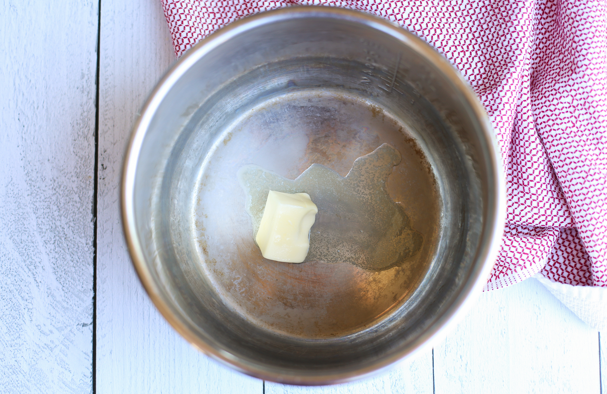 A couple tablespoons of butter melting in an Instant Pot.
