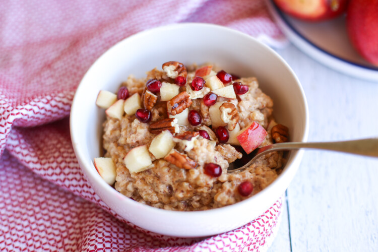 Apple cinnamon steel cut oats with chopped apples and pecan pieces on top.