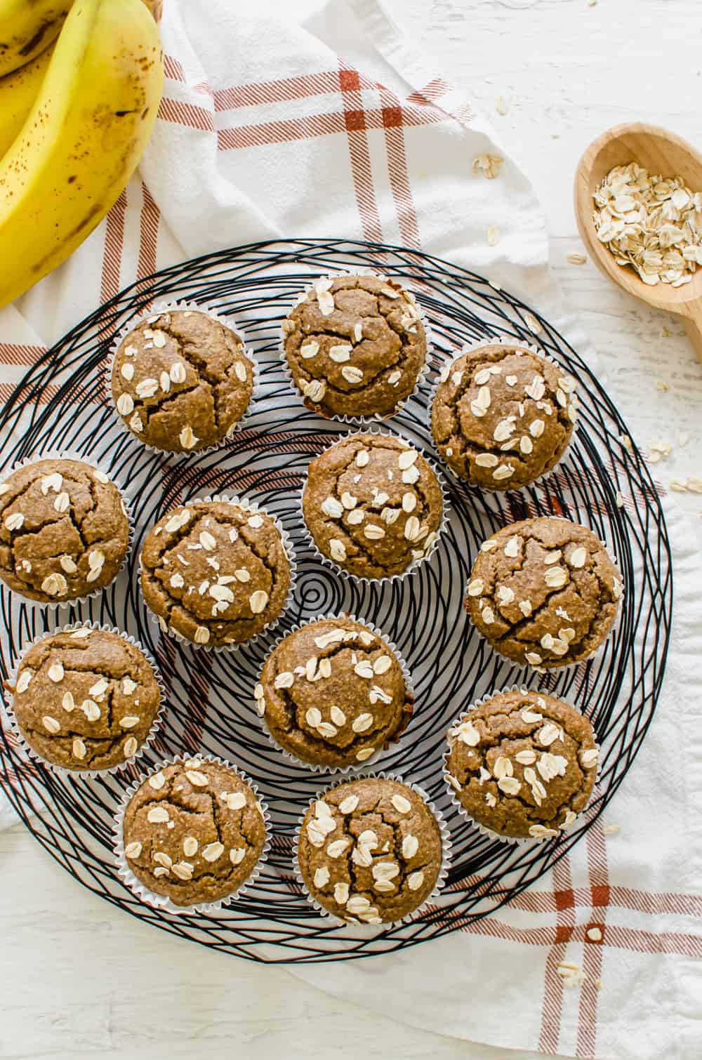 Gluten-free banana muffins with oats on top lined up on a wire serving tray.