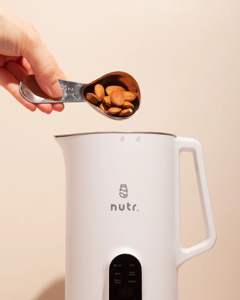 dumping almonds into a Nutr machine