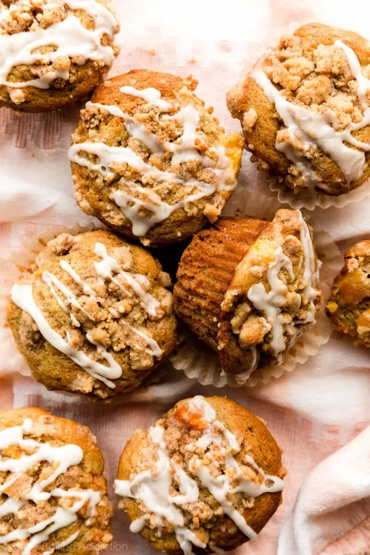 Peach Streusel Muffins stacked on a plate.