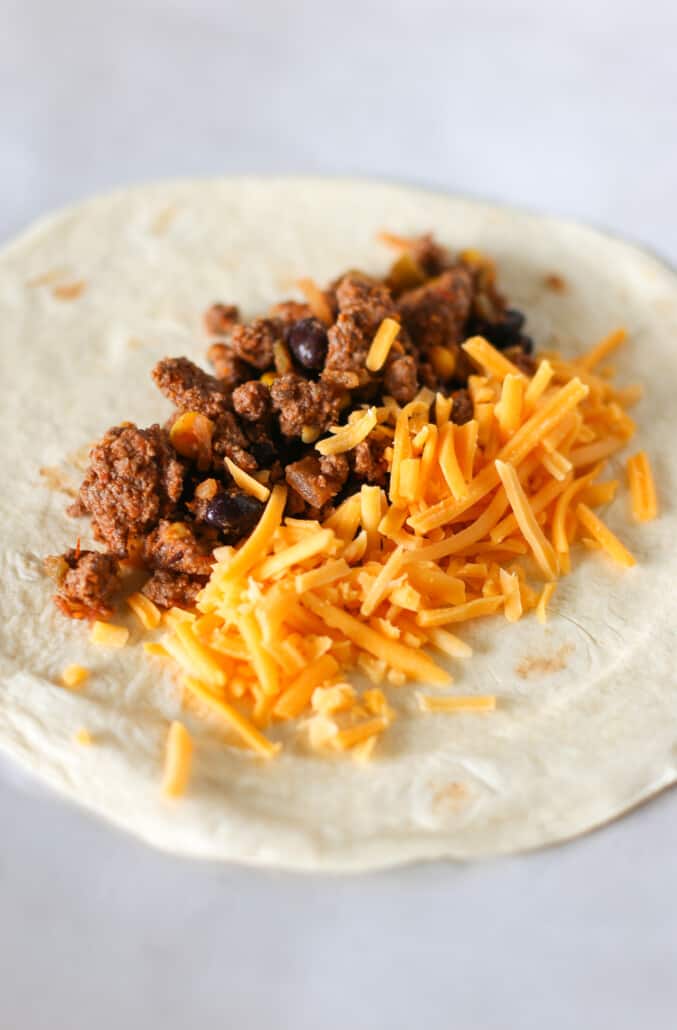 Assembling a burrito with ground beef and cheese