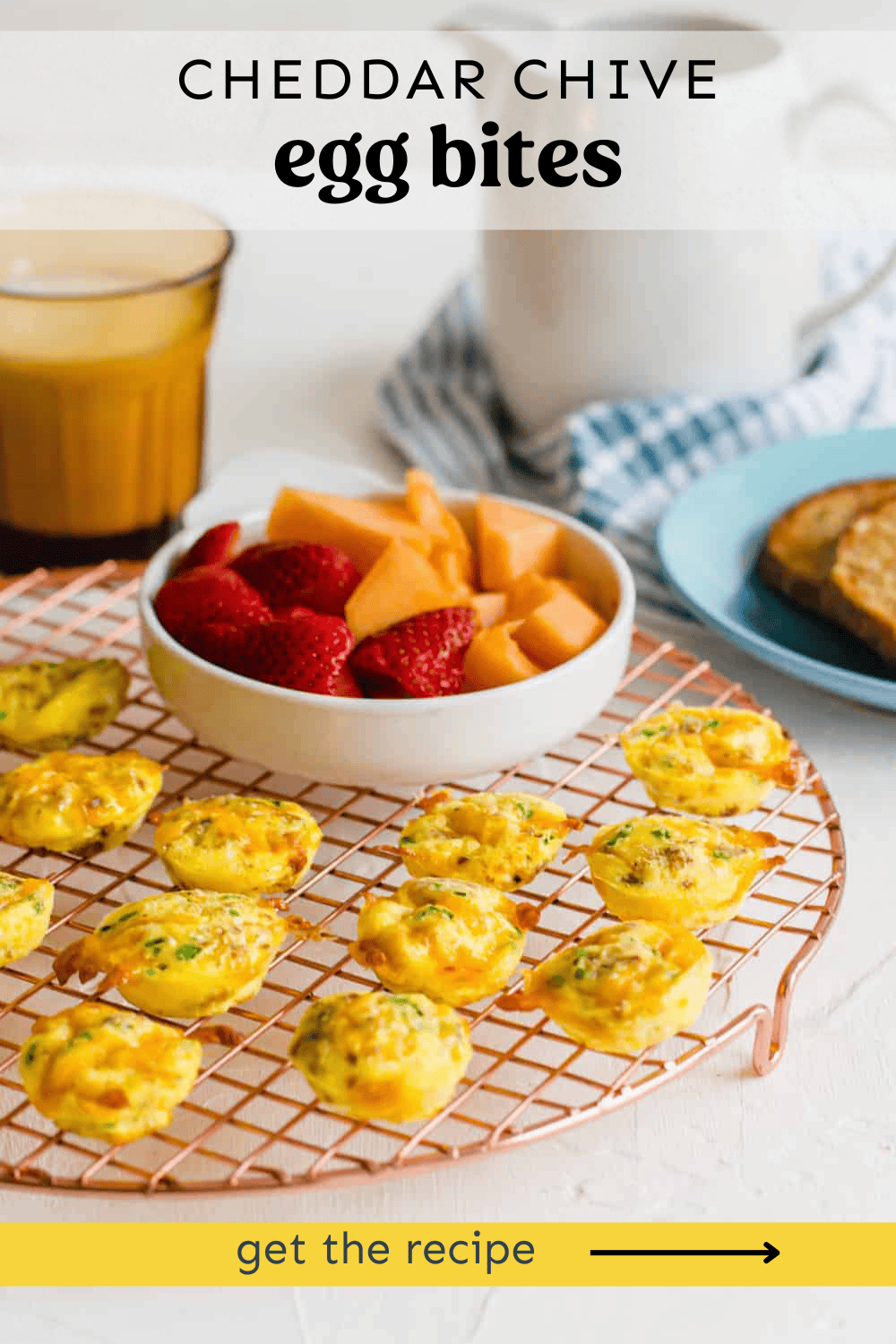 Egg bites on a cooling rack with a bowl of fresh fruit.