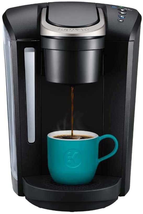 A black Keurig with an aqua mug being filled with coffee.