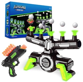Stock photo of an Astroshot with ping pong balls hovering over it, a Nerf gun next to it, and the original packaging in the background.