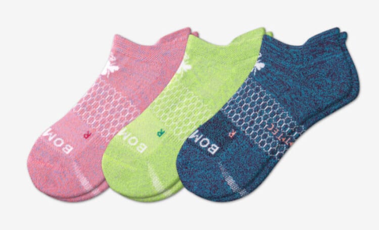 Pairs of pink, lime green and blue Bombas socks lined up.