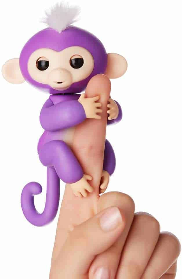 A purple Fingerling toy on a pointer finger.