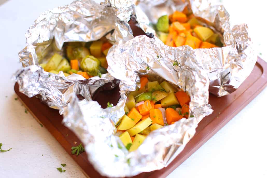 overhead shot of cooked vegetables in foil packs