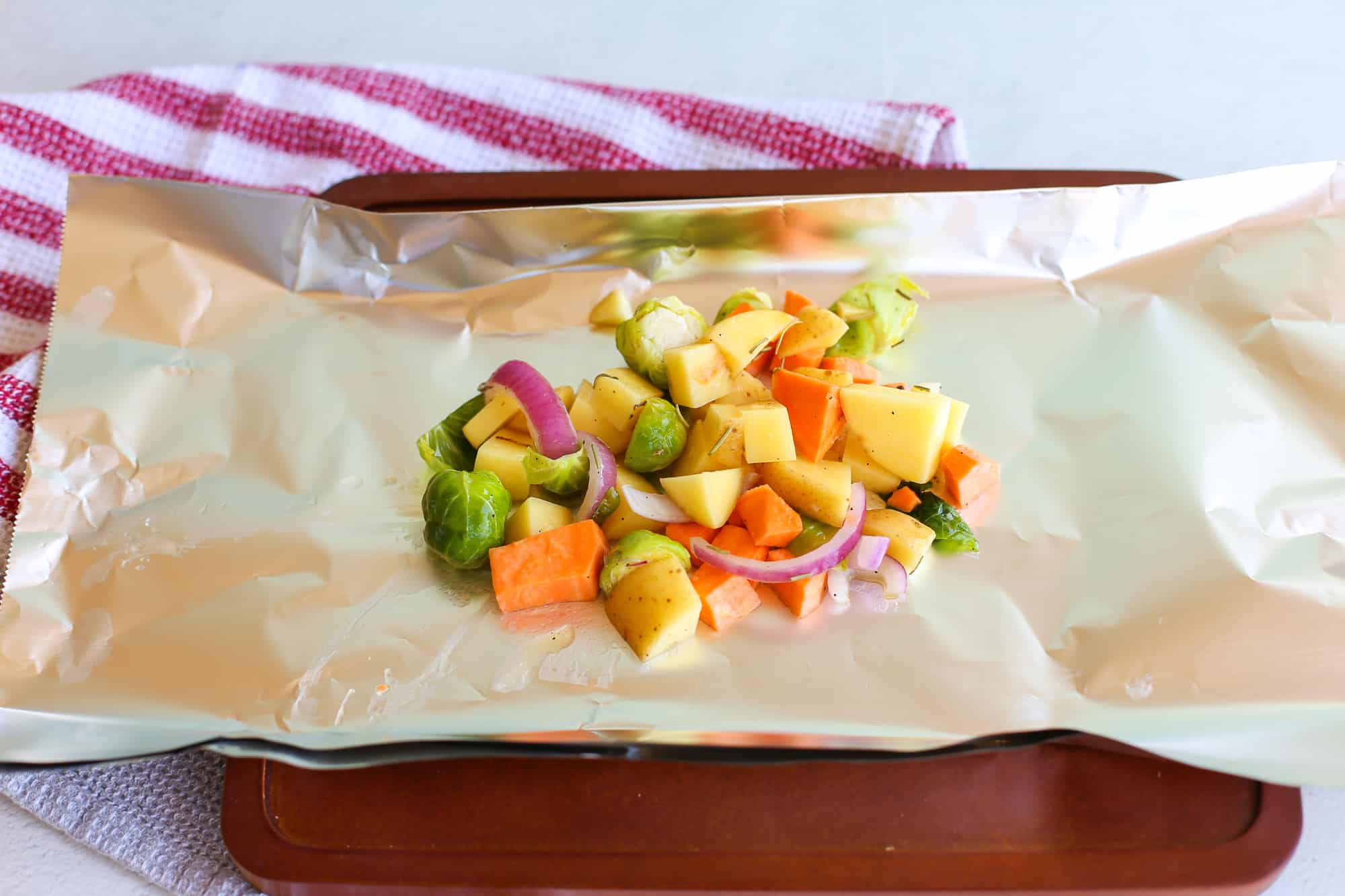 Foil square with veggies on it ready to be folded and put on the grill.