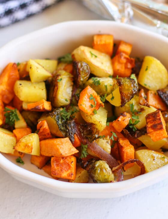 Roasted root vegetables in a white dish.