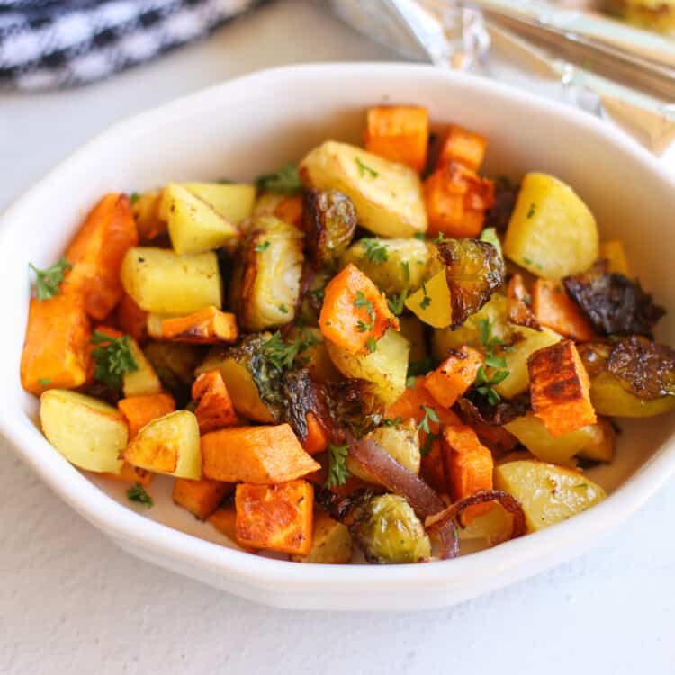 Roasted root vegetables in a white dish.