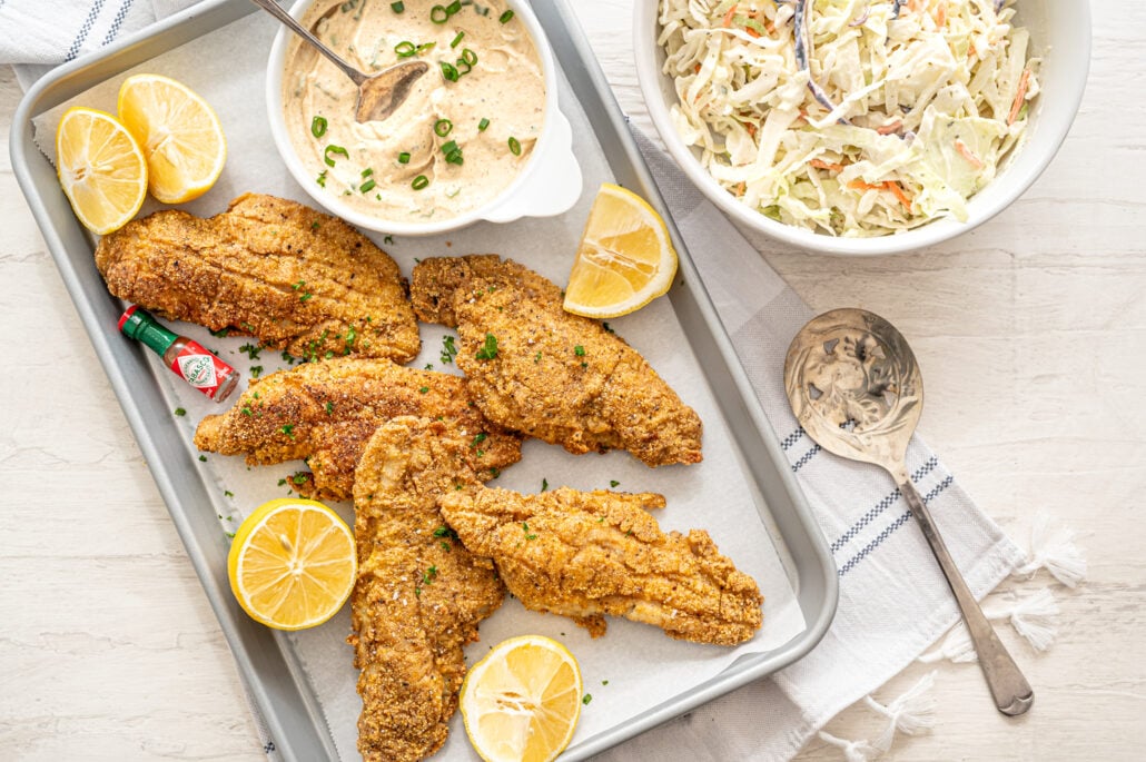 fried catfish on parchment with remoulade sauce and lemon wedges