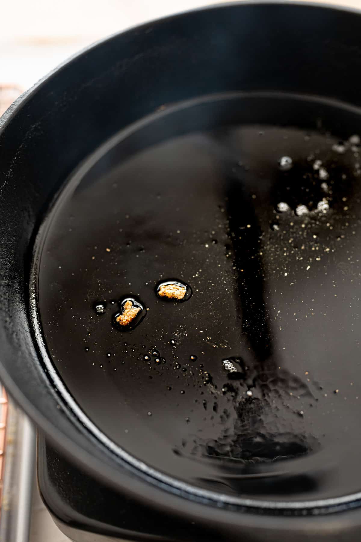 Hot oil in a cast iron skillet that is shimmering.