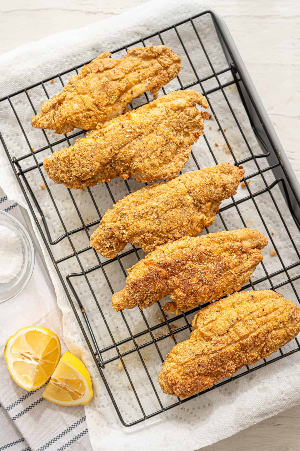 Fried catfish on a wire rack.