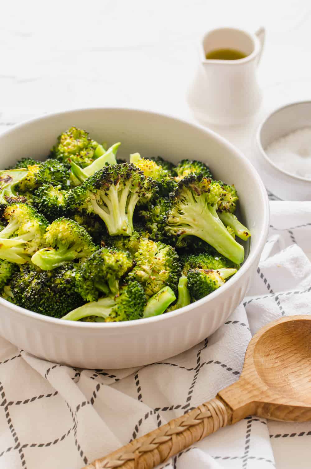 Oven roasted broccoli served in a white bowl.