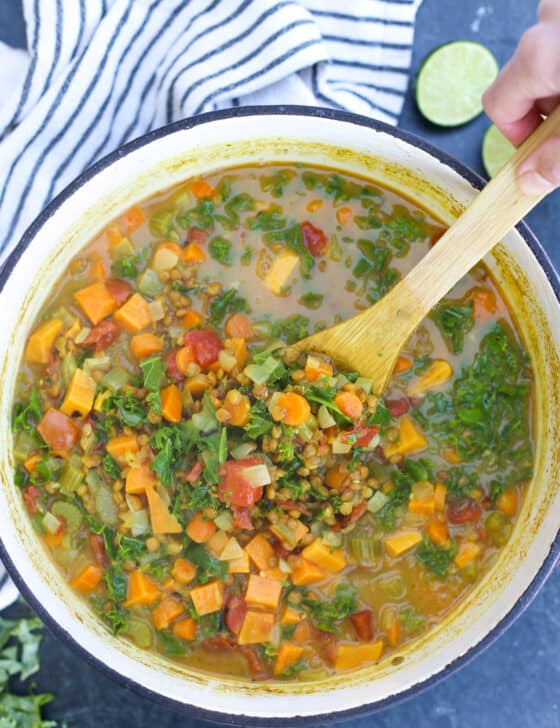 Coconut Curry Lentil Soup in dutch over with wooden spoon