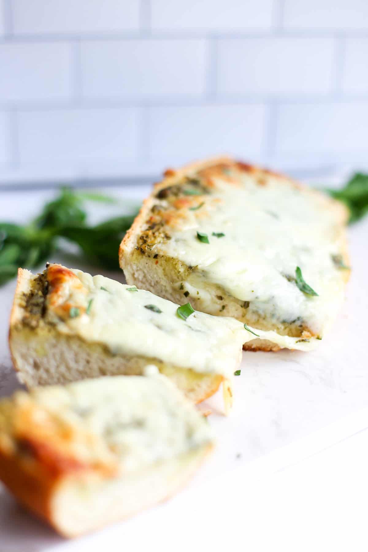 Pesto bread sliced on a piece of parchment paper.