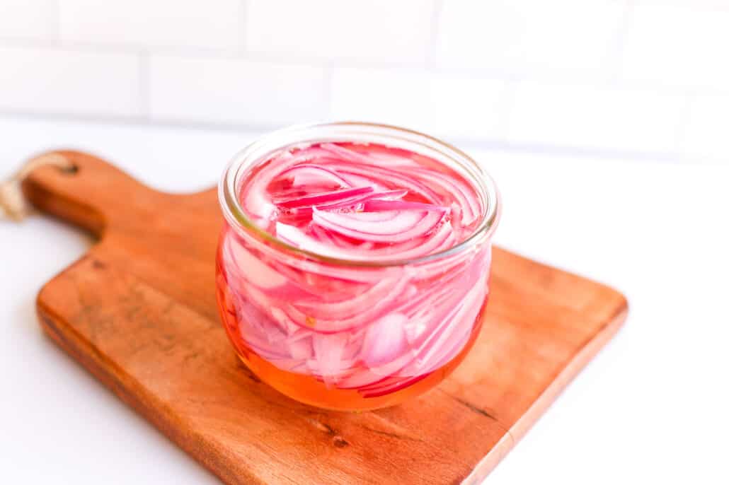 red onions in a jar being pickled