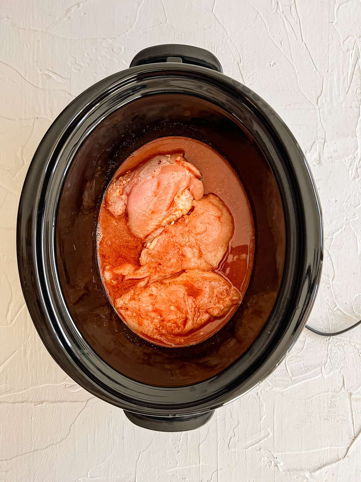 Raw Chicken in a slow cooker.