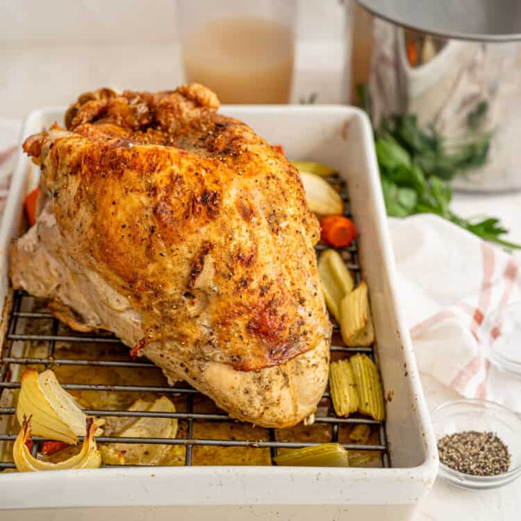 roasted turkey breast in a pan with gravy equipment and ingredients in the background