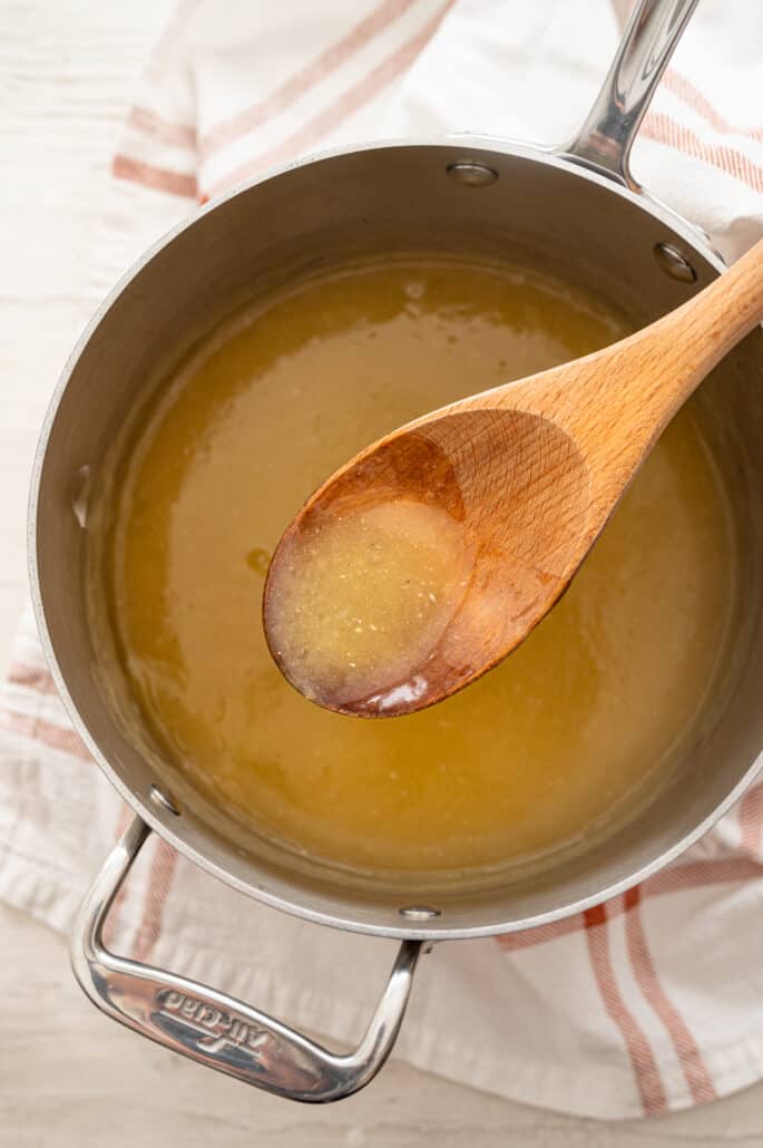 pot of turkey gravy and a spoonful of it showing the consistency of the gravy