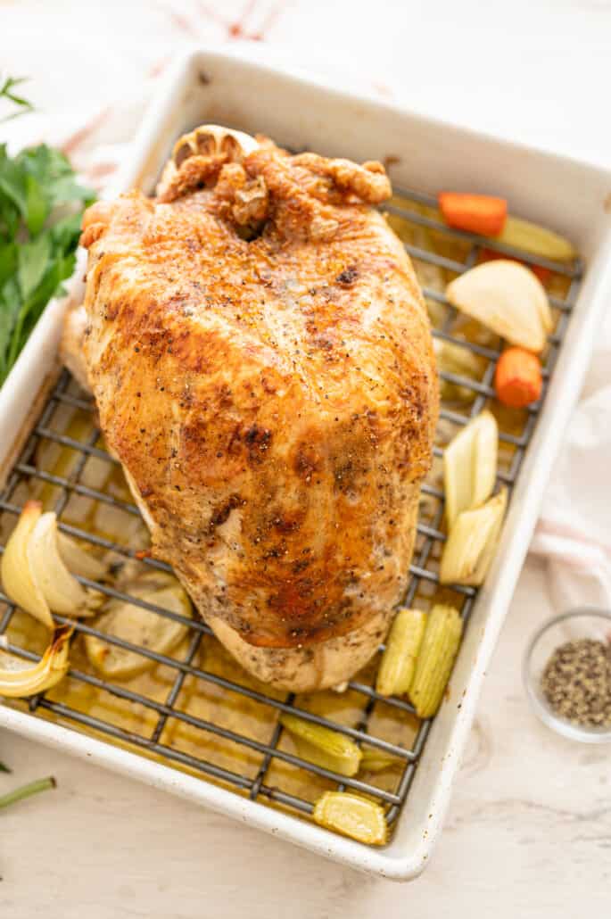 overhead shot of a roasted turkey breast on a rack in a pan