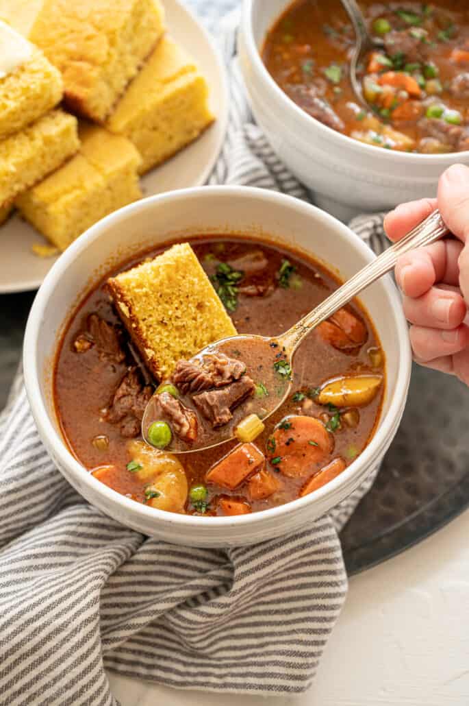 bowl of beef stew with cornbread on top