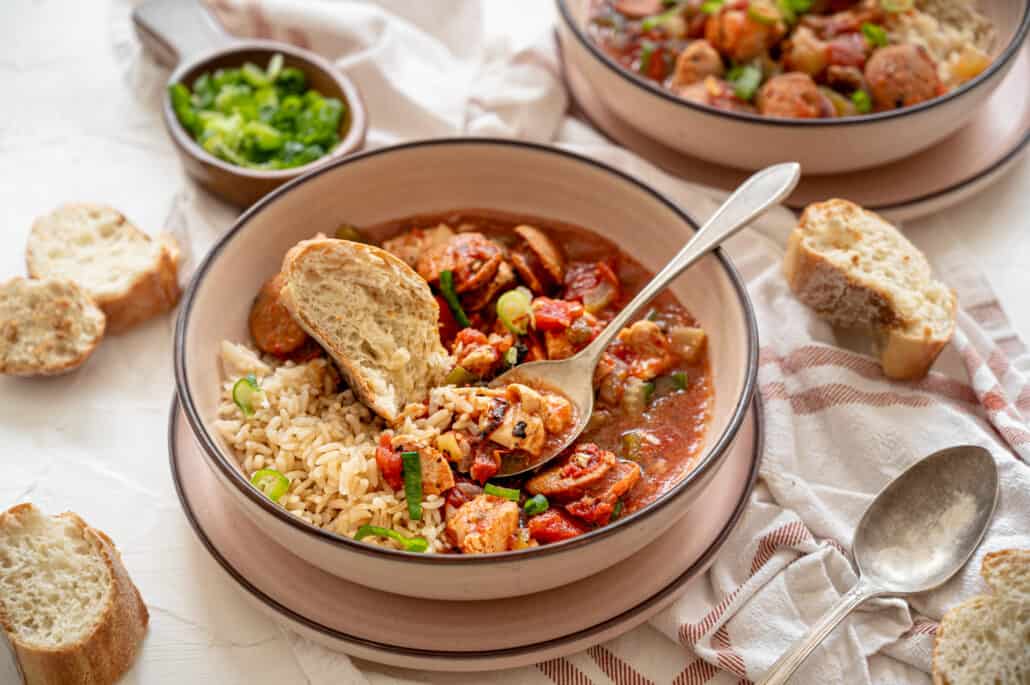 jambalaya over rice in bowl with spoon