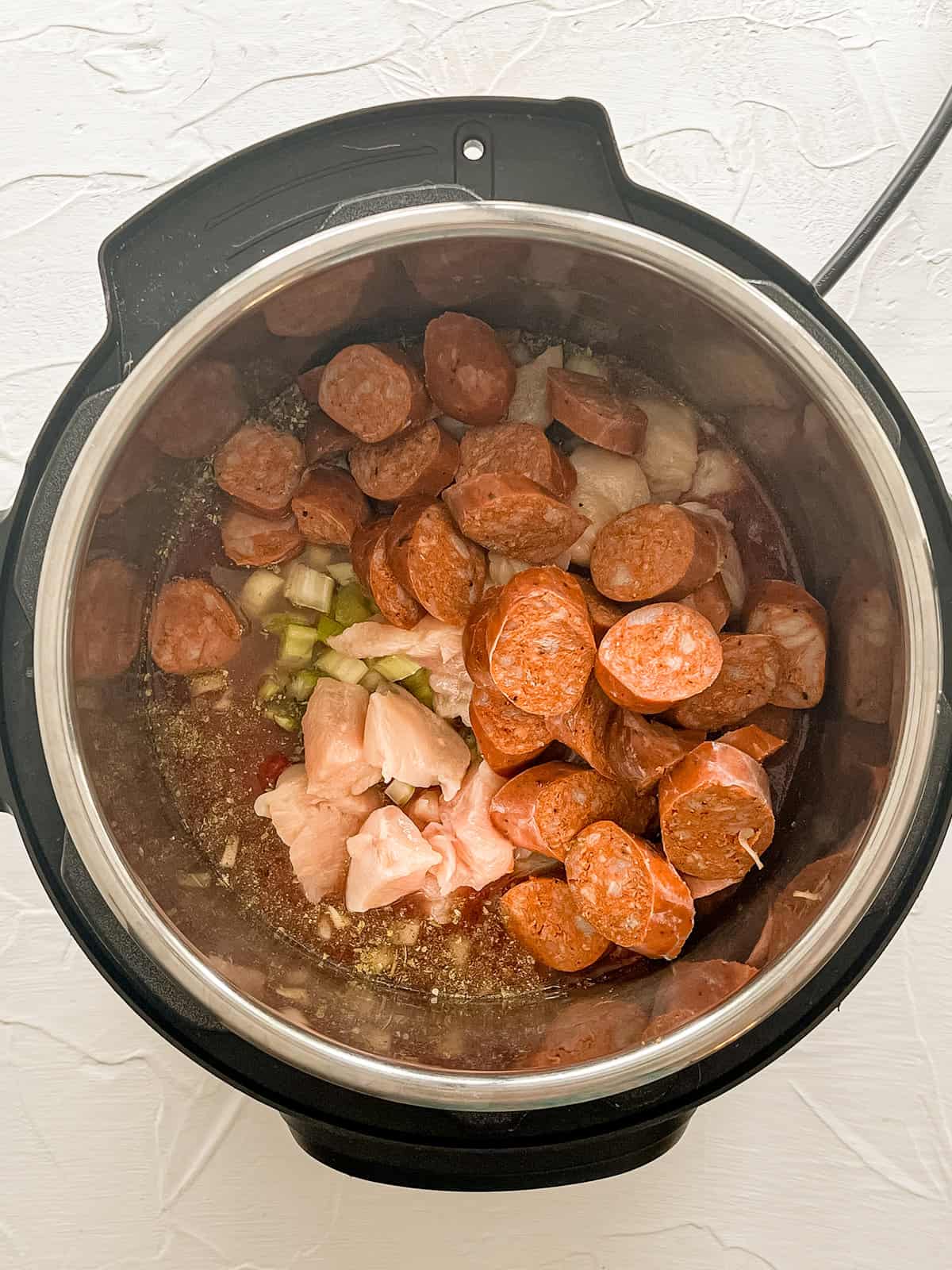 Raw jambalaya ingredients in an Instant Pot.