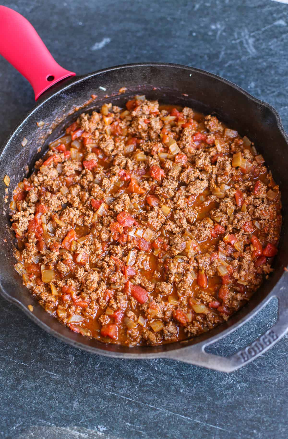 Taco meat simmering in a cast iron skillet.