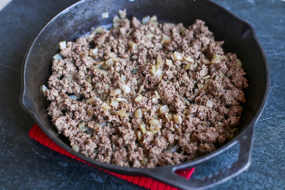 Browning Ground Beef and onion in a cast iron skillet.
