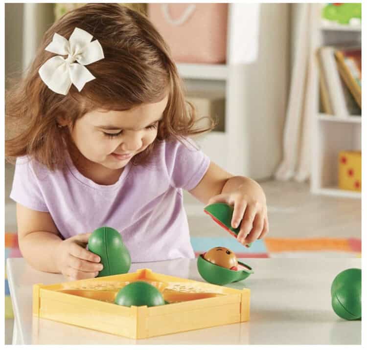 A girl playing with Learn-A-Lot Avocados.