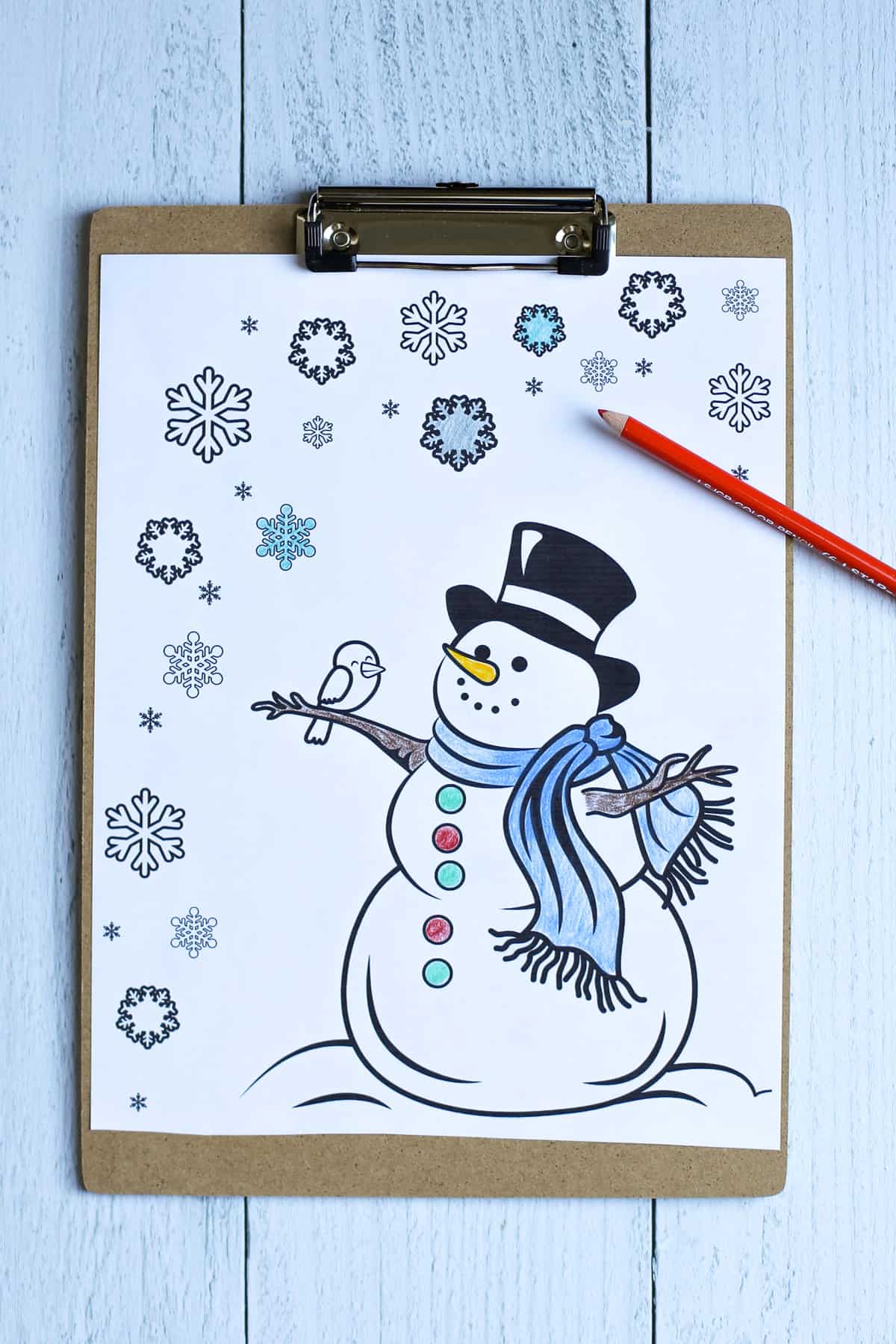 Snowman coloring page on a clipboard partially colored in.