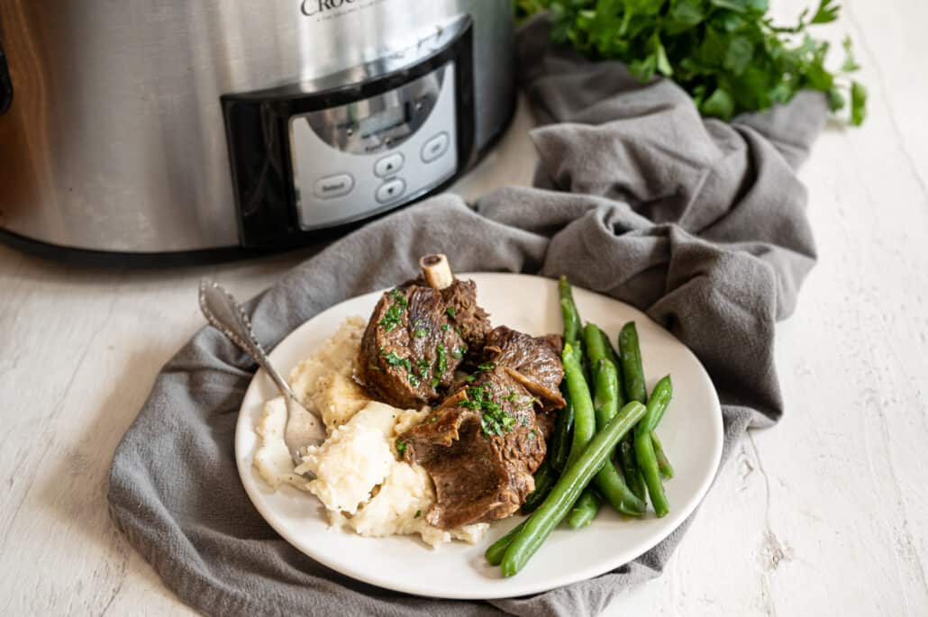 crockpot short ribs on plate with mashed potatoes and green beans