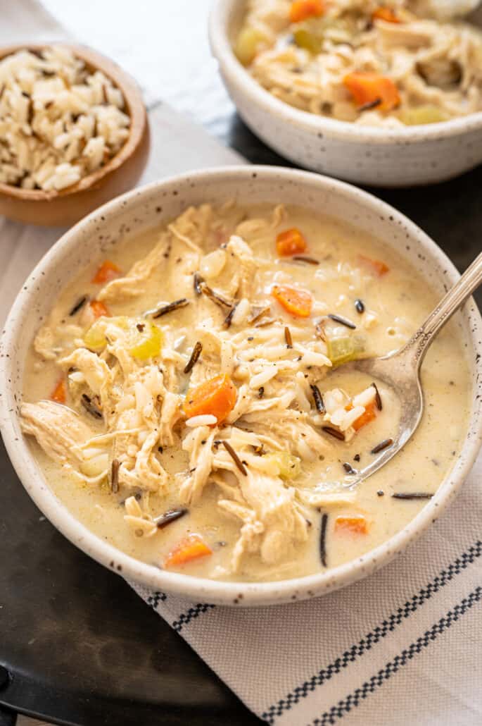 Chicken and wild rice soup in a white bowl with a spoon